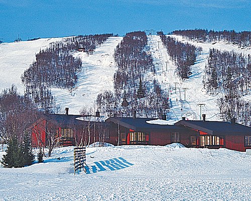 Exterior view of multiple units at Fjall Lien covered in snow during winter.