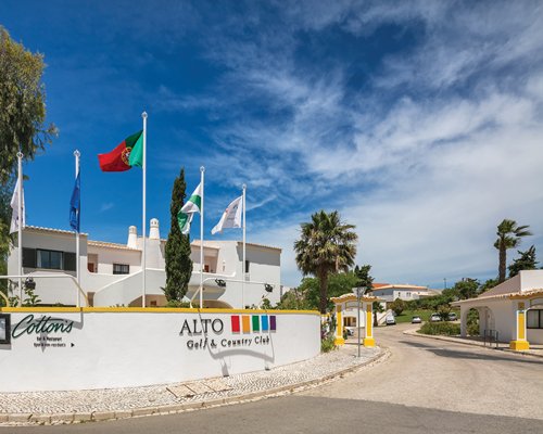 Entrance to Alto Golf and Country Club with four flags.