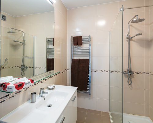 A bathroom with a closed sink vanity and shower stall.