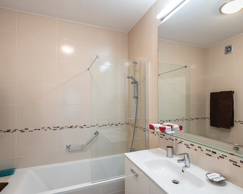 A bathroom with shower bathtub and closed sink vanity.