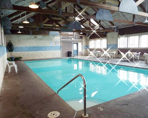 A large indoor swimming pool with patio furniture.