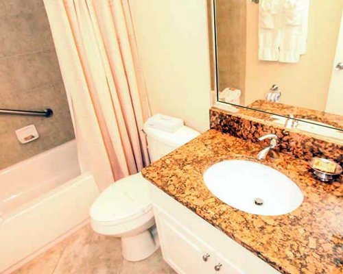A bathroom with a bathtub and a single sink vanity.