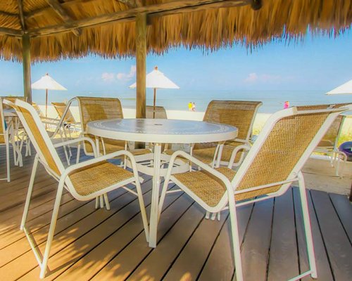 Thatched covered outdoor dining alongside the beach.