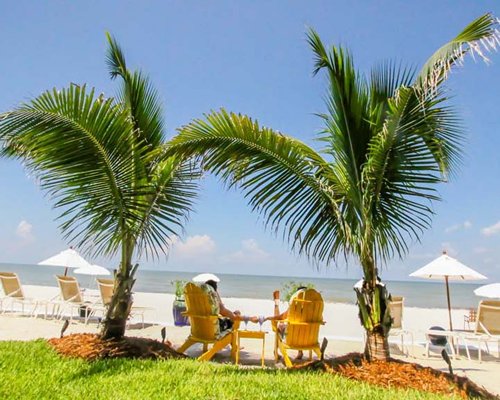 Beach view with chaise lounge chairs and sunshades facing the ocean.