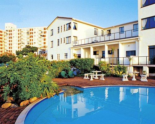 An outdoor swimming pool alongside multi story resort units.
