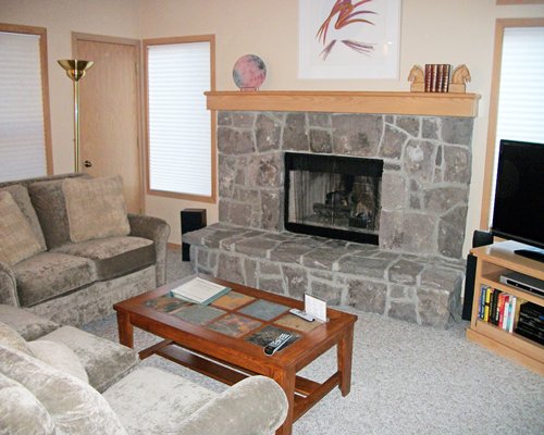 A well furnished living room with a pull out sofa and a fireplace.