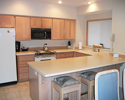 An open plan kitchen with a breakfast bar and dining area.