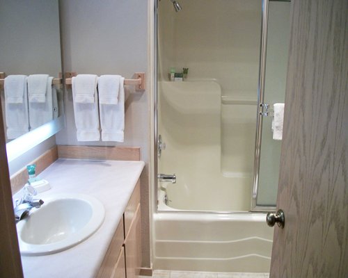 A bathroom with a bathtub and single sink vanity.