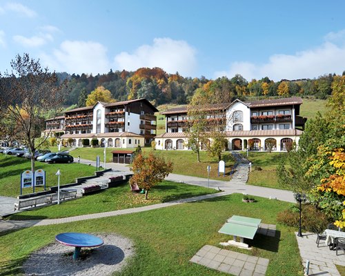Exterior view of Ferienclub Oberstaufen with outdoor picnic area and pathway.