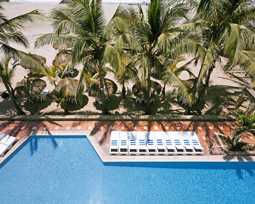An aerial view of a large outdoor swimming pool with chaise lounge chairs and.