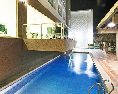 An outdoor swimming pool alongside multi story villas.