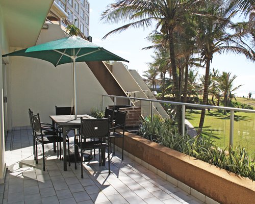 Balcony with sunshade and patio chairs with the scenic landscape.