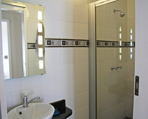 A bathroom with shower stall and sink.