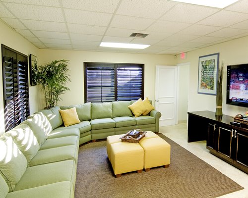 A living room with a pull out sofa ottoman and television.
