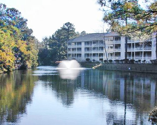 An exterior view of resort units alongside a waterfront.