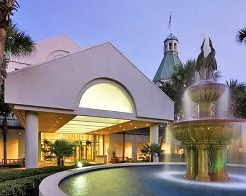 An exterior view of resort units alongside a fountain.