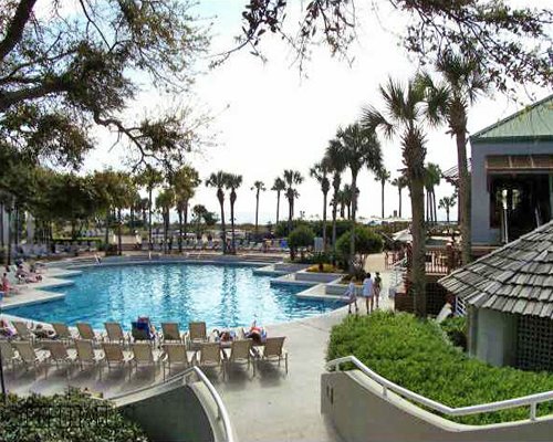 An outdoor swimming pool with chaise lounge chairs.