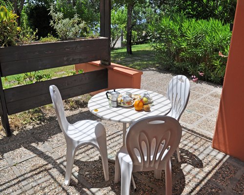 An exterior view of patio furniture alongside landscaping.