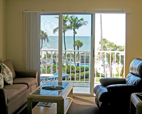 A well furnished living room with pull out sofa and a balcony with patio.