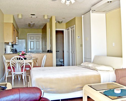 An open plan living room with a bed dining and kitchen area.