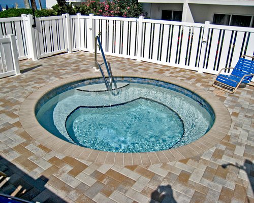 Outdoor hot tub with a chaise lounge chair.