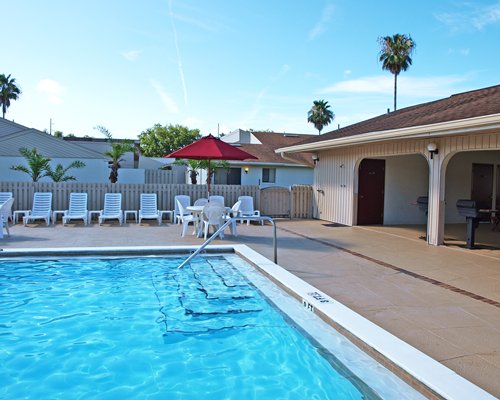 An outdoor swimming pool with chaise lounge chairs.
