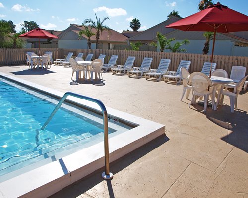 An outdoor swimming pool with chaise lounge chairs.