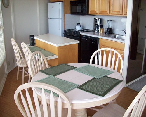 An open plan kitchen with breakfast bar and dining area.