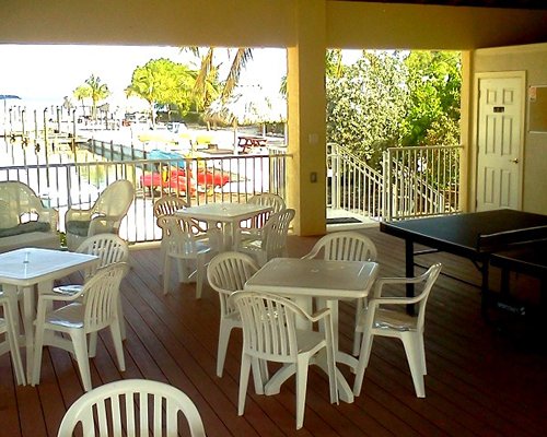 An indoor recreational area with ping pong table and patio furniture.