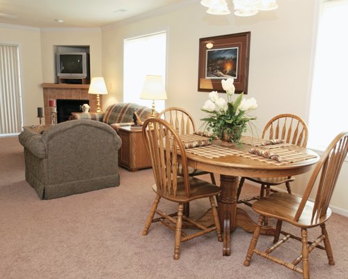 A well furnished living room with a television and dining area.