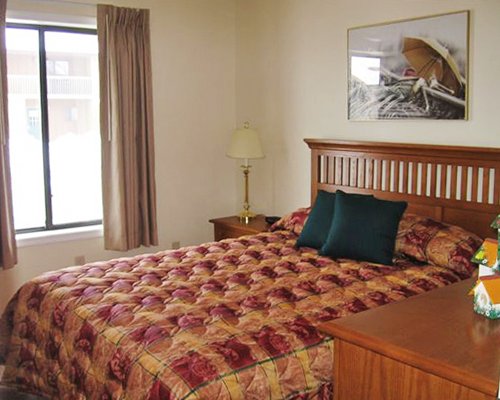 A well furnished bedroom with queen bed and outside view.