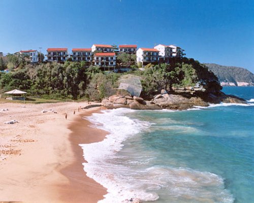 A beach alongside the ocean and resort units.