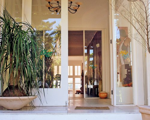 An exterior view of a resort unit alongside potted plants.