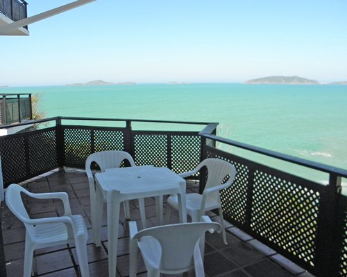 View of ocean from balcony with patio furniture.
