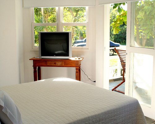 A well furnished bedroom with television and a patio.