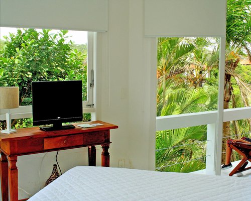 A well furnished bedroom with a television and a balcony.