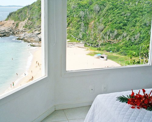 A seashore and the mountains from a bedroom.