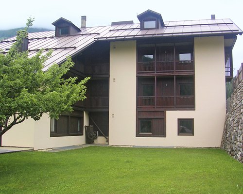 Exterior view of Domina Home Parco Dello Stelvio with parking lot and wooded area during winter.