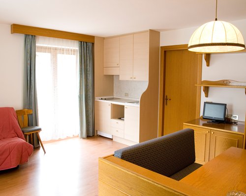 An open plan living room bedroom and dining area with television.