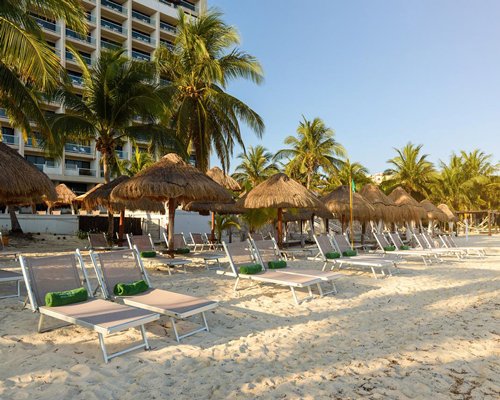 A view of an outdoor swimming pool alongside the beach.