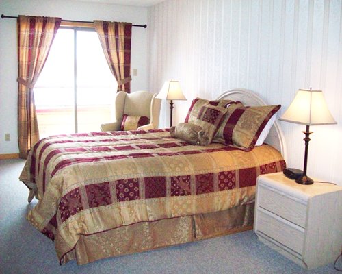A well furnished bedroom with two lamps and an outside view.