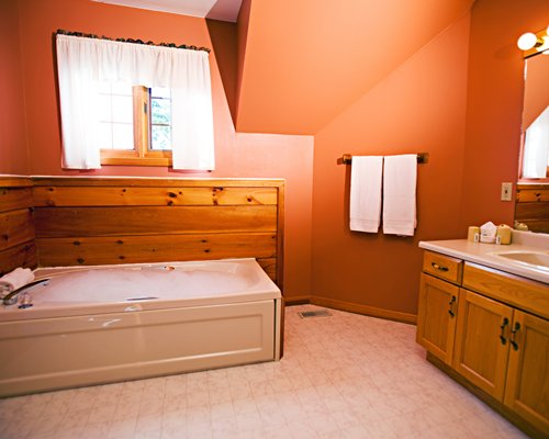 A bathroom with a bathtub and a single sink vanity.