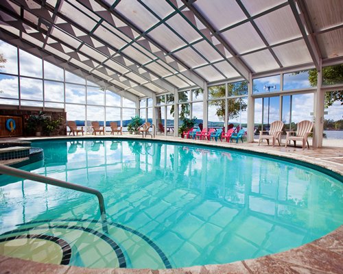 An indoor swimming pool with outdoor view.