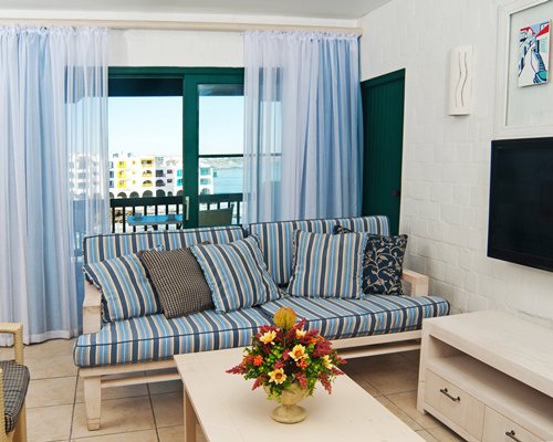 A well furnished living room with a television and balcony.