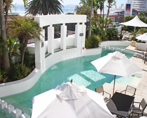 A view of waterfront alongside the patio furniture and sunshades.