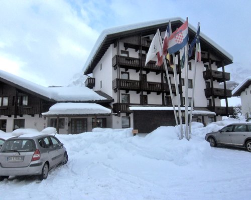 Exterior view of Residence Sport Hotel Astoria with a car during winter.