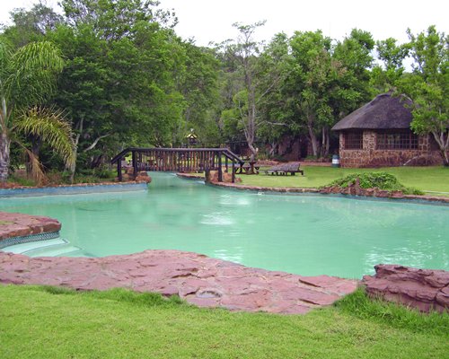 An outdoor pool alongside resort units and trees.