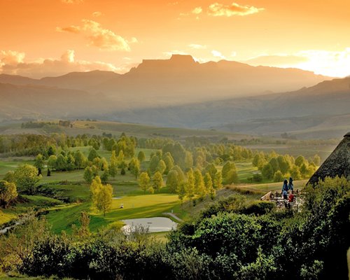 A view of the resort property at sunrise surrounded by hills and mountains.