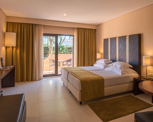 A well furnished bedroom with television and balcony.