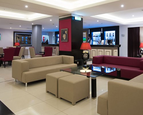 An indoor swimming pool with chaise lounge chairs.